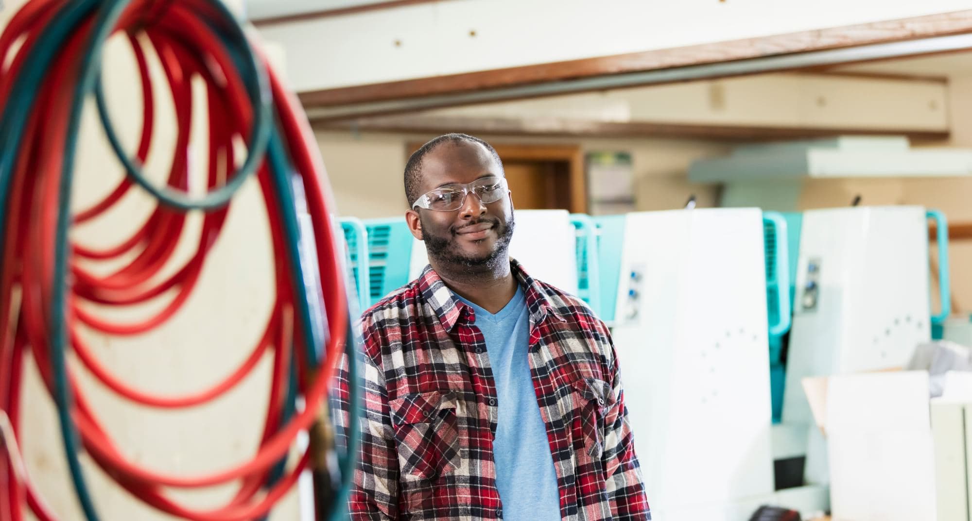 Worker wearing clear safety glasses in an industrial production facility.